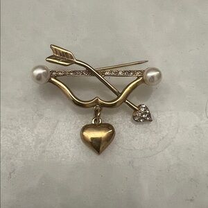 Decorative brooch . Gold color Metal, rhinestones.